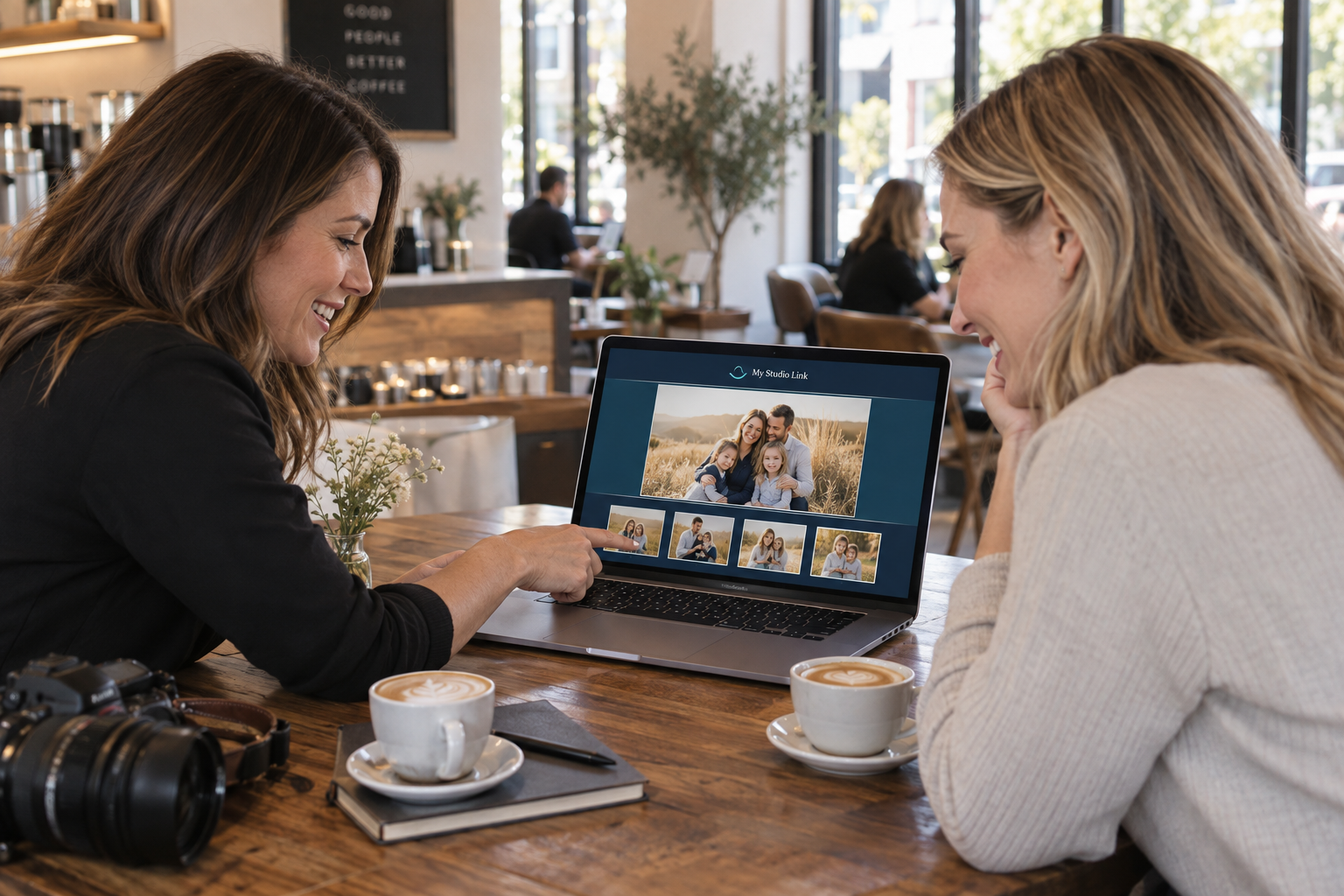 Illustrative photographer sharing family portraits with her client on a laptop in a coffee shop